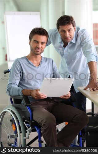 Man in wheelchair holding laptop