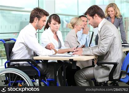 Man in wheelchair with colleagues in a meeting