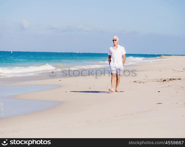 Man in white clothes on the beach on sunny day. Beautiful day on the beach