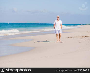 Man in white clothes on the beach on sunny day. Beautiful day on the beach