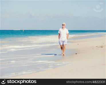 Man in white clothes on the beach on sunny day. Beautiful day on the beach