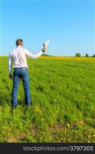 man in white shirt in the field with papers