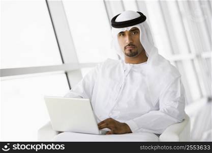 Man indoors with laptop (high key/selective focus)