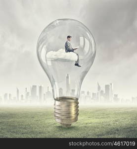 Man inside bulb. Young businessman inside of light bulb reading book