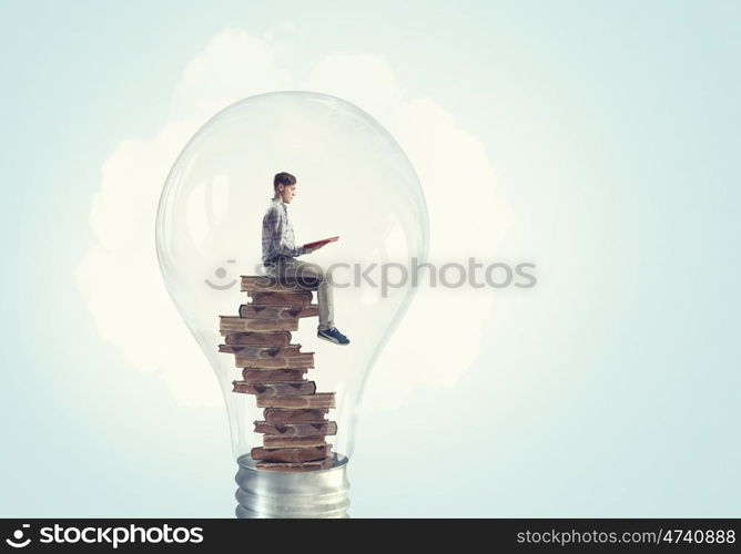 Man inside bulb. Young businessman inside of light bulb reading book