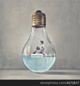 Man inside light bulb. Young businessman floating on life buoy inside of light bulb