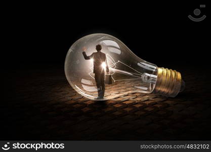 Man inside of electric bulb. Thoughtful businessman inside glass light bulb as brainstorming concept