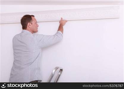 man installing a protection on a wall