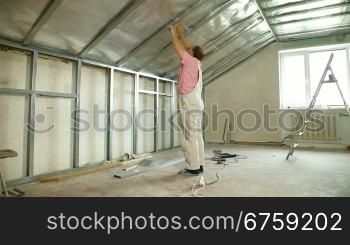 Man installing drywall on ceiling