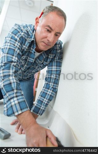 man installing floor in a room