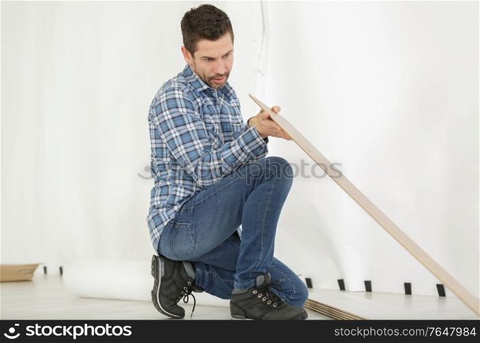 man installing new laminated wooden floor close up