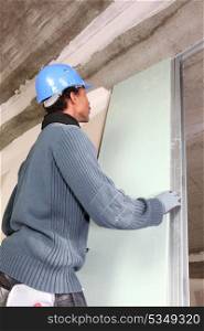 Man installing plaster board panel