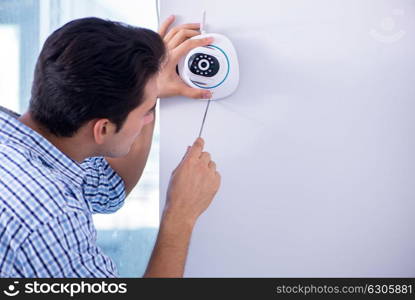 Man installing surveillance CCTV cameras at home