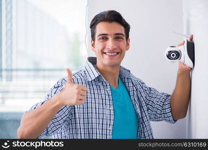 Man installing surveillance CCTV cameras at home