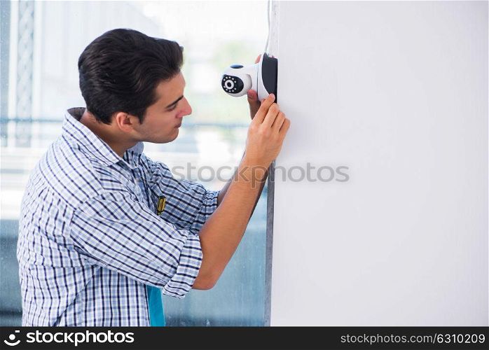 Man installing surveillance CCTV cameras at home