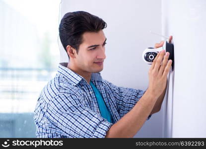 Man installing surveillance CCTV cameras at home