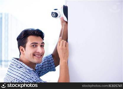 Man installing surveillance CCTV cameras at home. The man installing surveillance cctv cameras at home