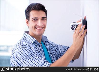Man installing surveillance CCTV cameras at home. The man installing surveillance cctv cameras at home