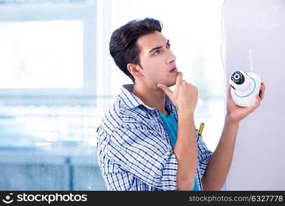 Man installing surveillance CCTV cameras at home. The man installing surveillance cctv cameras at home