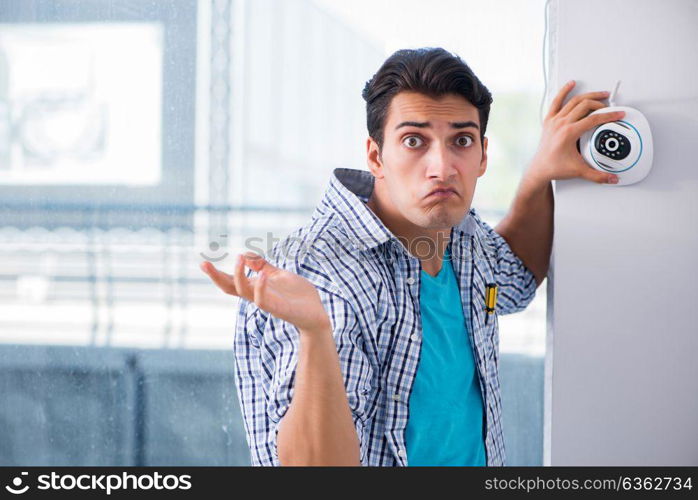 Man installing surveillance CCTV cameras at home. The man installing surveillance cctv cameras at home