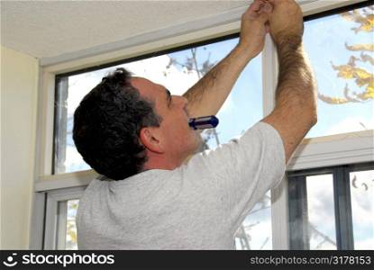 Man installing window blinds in a house