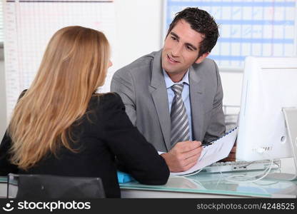 Man interviewing a young woman across a desk