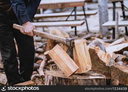 Man is chopping wood with vintage axe. Detail of flying pieces of wood on log with sawdust.. chopping the log
