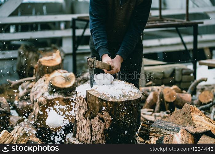 Man is chopping wood with vintage axe. Detail of flying pieces of wood on log with sawdust.. chopping the log