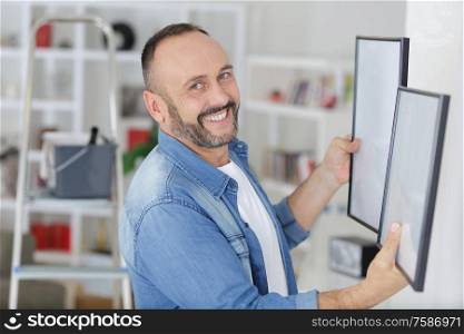 man is deciding where hanging the picture