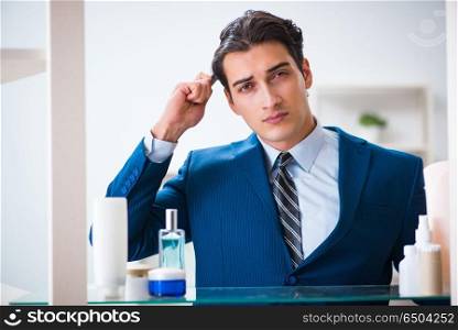 Man is getting dressed up for work in bathroom