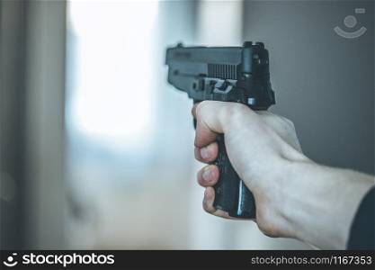 Man is holding a black fire weapon, closeup