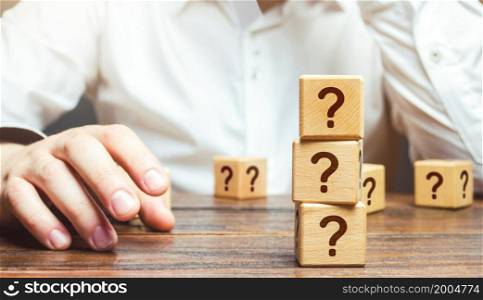 Man is in thought and blocks with questions. Pondering the problem, gathering all the facts. Make the right decision. Reasoning, weighing results and consequences. Reflection and planning. Strategy.
