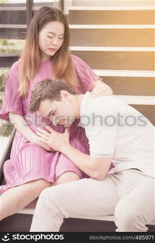 man is listen pregnant of wife, asian handsome father take care mother with couple and expect maternity have a happy, love of family concept.