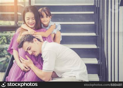 man is listen pregnant of wife, asian handsome father take care mother and kid with couple and expect maternity have a happy, love of family concept.