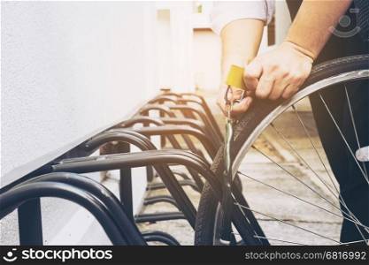 Man is locking key chain for his bicycle in campus