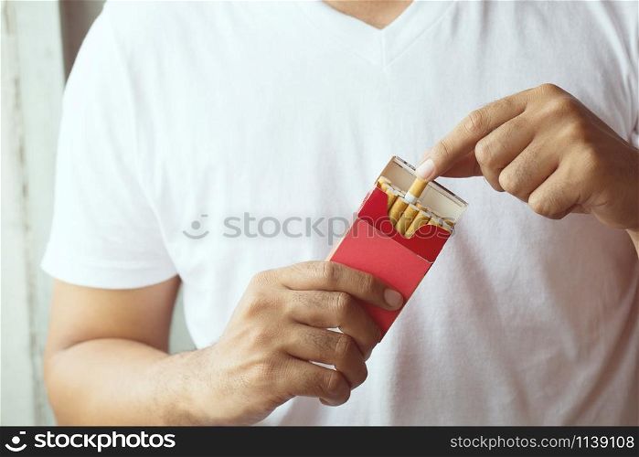 Man is picking Cigarette from Package come up smoking.
