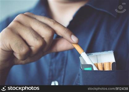 Man is picking Cigarette pack from the pocket Come up smoking.