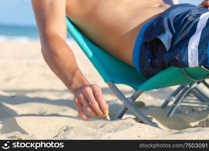 man is smoking at the beach