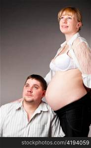 man is trying to listen his baby inside of his pregnant wife