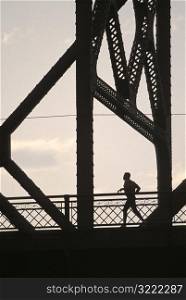 Man Jogging Across a Bridge