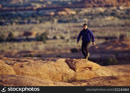Man Jogging Over Red Rocks