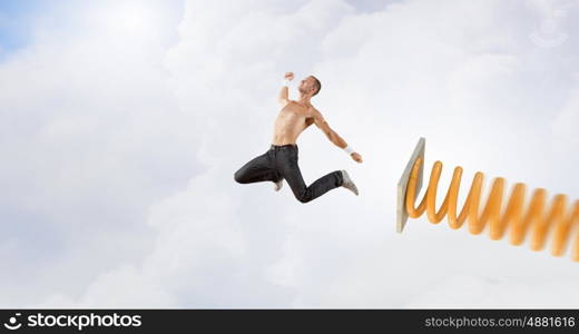 Man jump on springboard. Young man jumping on spring and flying in air