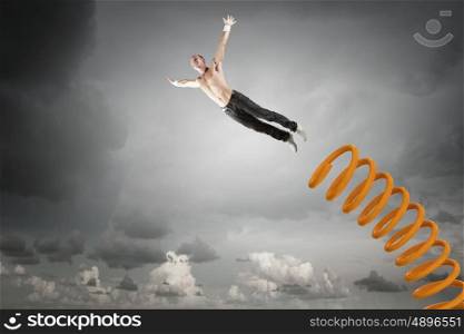 Man jump on springboard. Young man jumping on spring and flying in air