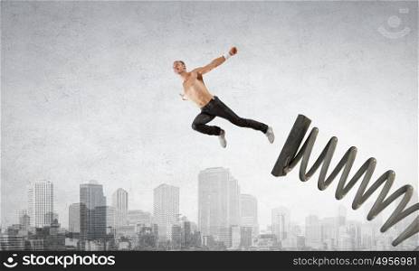Man jump on springboard. Young man jumping on spring and flying in air