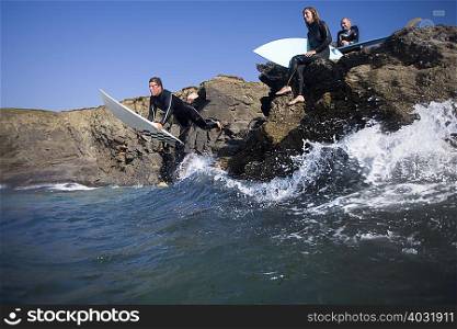 Man jumping into water on surfboard