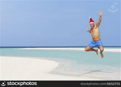 Man Jumping On Beach Wearing Santa Hat