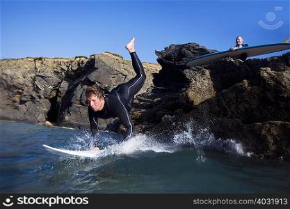 Man jumping onto surfboard