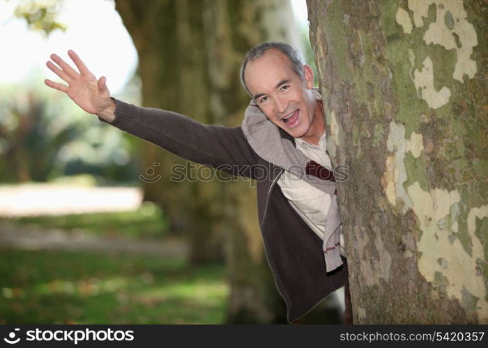 Man jumping out from behind tree