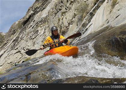 Man kayaking in mountain river