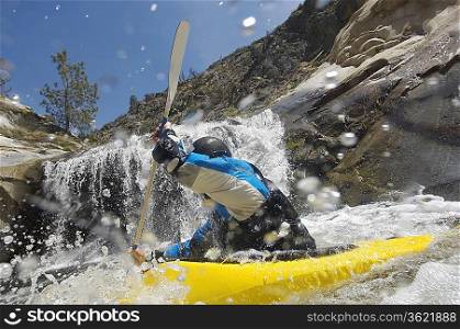 Man kayaking in mountain river